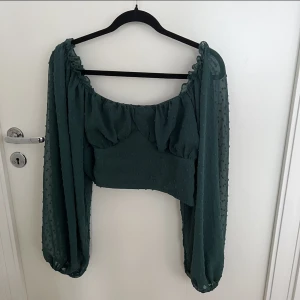 Smaragdgrön blus - Smaragdgrön blus med fina flowiga armar. Man kan ha den offshoulder eller inte.  Strl L men passar ca M Superfin men tyvärr för stor för mig