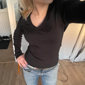 Svart v-ringad tröja! - En fin svart basictröja med v-ringning som gör den lite extra. Fina detaljer vid ringningen från ett märke som heter Edc. Den är i mycket bra skick i storlek S. Säljer för 90 kr. 