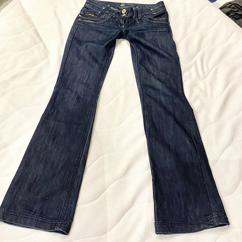 Lågmidjade jeans med sjukt coola bakfickor. Jeansen är utsvängda/raka och har många guld detaljer. Dom är i bra skick har inga hål, fläckar osv.  Innerbenslängd: 83cm  Midjemått: 40cm  Köpare står för frakten💗. Jeans & Byxor.