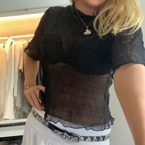 Svart blus - En svart blus i ett genomskinligt stretchigt material. Den är i L men passar bra på mig som är en s