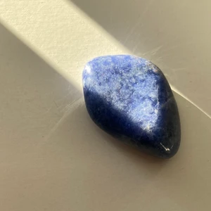 kristall, sodalit - trumlad sodalit, ca 4 cm lång. första bilden är på kristallen i solen för att visa färgen bättre. säljer pga att jag slutat med witchcraft. om du har några frågor är det bara att skriva❤️