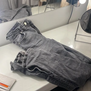 Gråa jeans slits - Gråa fina jeans med slits i stlk 34  Använt några få gånger tills jag ej kunde ha dom pga viktuppgång, köpta för 800kr 