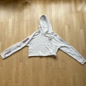 Vit hoodie ifrån Hollister - En vit hoodie med detaljer på i stolek S ifrån hollister. Är en magtröja och därav lite kortare. Längd: 40 cm. Fler bilder kan fås och kan skicka den!