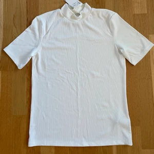 Vit topp med prislapp - Vit topp som ej är använd. Storlek M. 