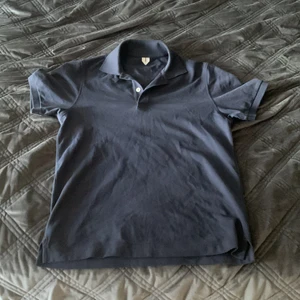 Arket Piké Navy Blue - En jättefin piké från Arket. Arket gör fina kläder av högsta kvalite. Sparsamt använt och i mörkblå färg. Släng iväg ett meddelande för ett pris