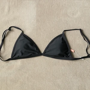 Nly Bikinitopp - Svart triangel bikinitopp i nyskick, aldrig använd så prislappen sitter kvar. Kommer inte till användning. Justerbara band med knäppe ibak. Finns även uttagbara inlägg☺️