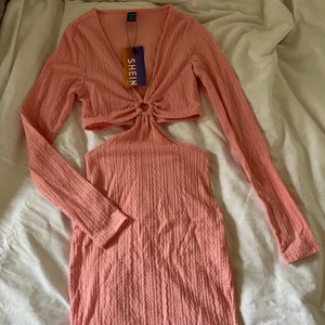 Helt ny rosa klänning strl S - Helt ny rosa klänning i storlek S! Aldrig använd, rosa stickad / virkad / ribbad. Längden är som en vanlig ”miniklänning”, långärmad, med cut outs i midjan. Detalj vid magen. Ser ut som en klänning framifrån och kjol + topp bakifrån. Frakt 52kr🥰