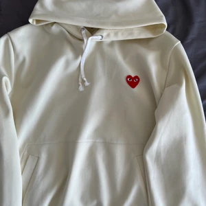 Comme des Garcons PLAY Hoodie  - Väligt clean Hoodie i 100% poyester. Köpt för ca 3år sedan på END, kostade då 2500kr. Använd vid max 10 tillfällen. Defekter innefattar knottret på ryggen samt en pytteliten fläck på ryggen som säkert går bort i tvätten (bild 2&3). Skulle säga cond 8/10. Storlek XL men passar mer som en L eller oversize M.  Skriv gärna om ni vill ha fler bilder!:) Fast pris och frakten bjussar jag på. Kram!❤️☮️