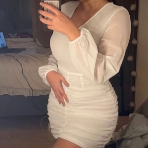 Studentklänning - Superfin vit klänning med meshtyg och ruch på kjolen som ger jättefin form när klänningen är på. Passar perfekt för student eller liknande. Helt oanvänd strl 38. Köpt på NAKD