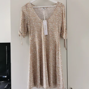 Känning - oanvänd!  - Somrig klänning strl M, aldrig använd. Kommer från rök och djurfritt hem. Skickas spårbart med Postnord. 