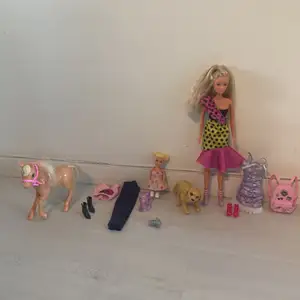 Lekia Barbie pack innehåller 2 Barbie dockor en stor en liten 2 outfits till den stora och en outfit till den lilla häst,hund,ryggsäck och kamera färg typ alla färger längd på stora Barbie dockan är 30 cm den lilla Barbie dockans längd är 11 cm 