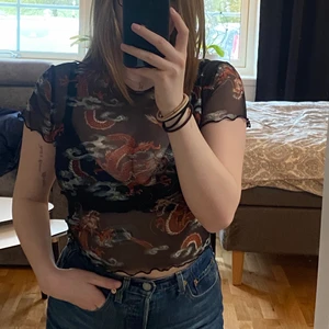 Mesh T-shirt  - Mesh T-shirt med drakar på, köpt på carlings. Storlek S men skulle säga att den mer är som en M. Säljer då den ej kommer till användning. Sparsamt använd. 