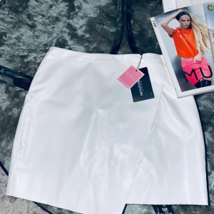 Läderkjol fake strl. 16  - Läderkjol vit. Låg midja. Liten storlek. Aldrig använd.