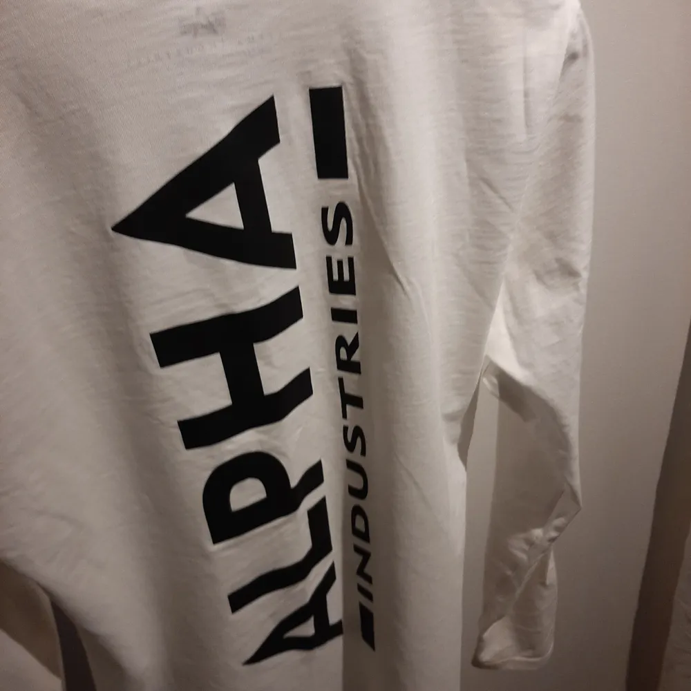 Vit Alpha Industries långärmad t-shirt, har använt den 2-4 gånger, inga fläckar eller liknande.. Skjortor.