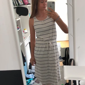 Vit randig Klänning med snören - Jag säljer denna söta klänningen för den kommer inte till användning längre. Köpt längesen från PompDeLux men är i bra skick. Storlek 146/152 men passar XS bra❣️
