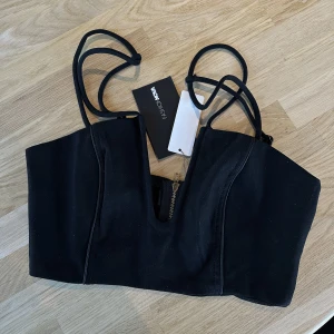 Black party top - Festtopp med v-snitt framtill och unik axeldesign.  Helt ny med taggar kvar.  Storleken är XS. Från Fashion Nova ♥️