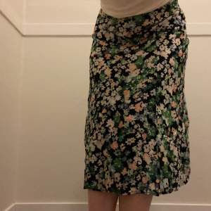 En somrig kjol som går halvvägs ner på vaden! Lätt att stylea färgerna (se bild 2) och passar perfekt på sommaren när det är lite varmare eller på våren med strumpbyxor under. Säljer pga för liten i midjan, en krok som ska fästa över dragkedjan saknas
