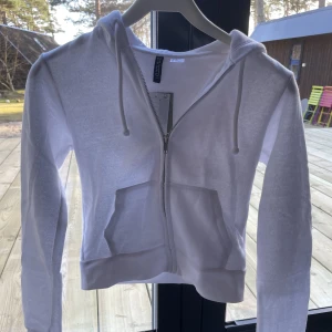 Vit kort zip-up hoodie - Jag säljer denna vita korta kofta då den är för liten för mig. Har aldrig använt och lappen är kvar💓