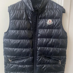 Moncler vest - Säljer en Moncler vest i nyskick! Storlek: 14 yrs (motsvarar XS). Orginalbox och dustbag ingår! Skriv vid fler bilder eller vidare frågor.