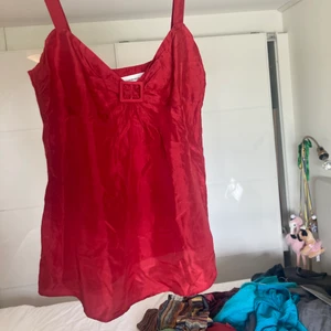 Röd silkestopp - Säljer denna fina silkestopp! Färgen kommer inte riktigt fram på bilderna, det är en dov röd. Det är 100% silke, jättefin kvalitet och skick!☀️ skriv för fler frågor