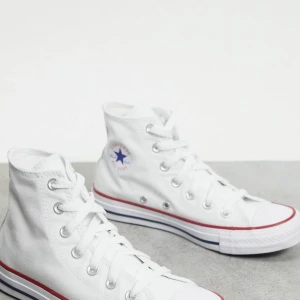 Converse skor - Säljer mina vita höga converse pågrund av fel storlek. Skorna är i storlek 38 men passa även 39. Perfekta och snygga skor nu till våren och sommaren. Skorna är i bra skick men har dock lite slitningar på framdelen men bara använda ett par gånger.