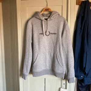 Fred Perry hoodie - Grå Fred Perry hoodie - Strl: M - Skick: lite nött i kragen och i ärmen, se bilder. - Nypris: 1300kr