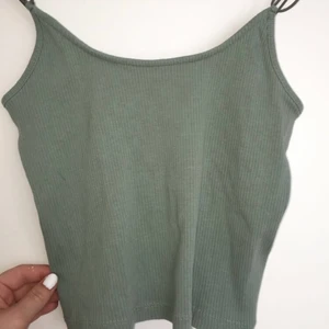 Grågrön söt topp - Supersöt grågrön topp från lager 157 i storlek m/l! Den slutar typ vid naveln och har söta ”trådsnören” som detaljer!