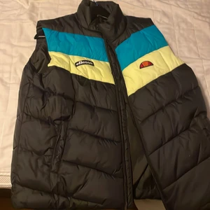 Dunväst Ellesse - Mörkblå dunväst med ränder. Fint skick, lite tunnare variant. Jätteskön. 