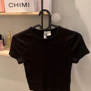 En helt vanlig svart t-shirt från hm som aldrig är använd, den är ribbad och är i storlek S! Köpt för 69 kr om jag minns rätt, tryck inte på köp direkt!!30 kr + frakt.