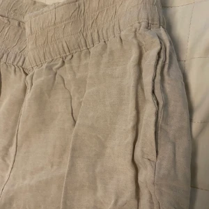 LINNEBYXOR - Linnebyxor från H&M! Storlek M. Beige färg och endast fickor längs sidorna (första bilden). De har tyvärr blivit för små för mig så har ingen bild på hur dem sitter på! De var lite kortare på mig och jag är 1.73. 