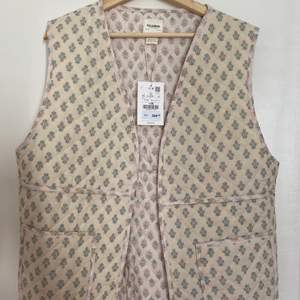 Floral slightly quilted vest. Unworn with tag. Cotton fabric.