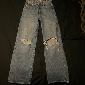 Vida jeans - Ett par blå vida jeans från lager 157. De är i modellen boulevard och har 2 hål på knäna. 
