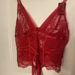 Röd body  - Röd spetsbody från hunkemöller, aldrig använd då kag köpte i fel storlek och hann inte lämna tillbaka den, prislapp finns kvar, nypris 399kr säljer den för 200kr🫶🏼