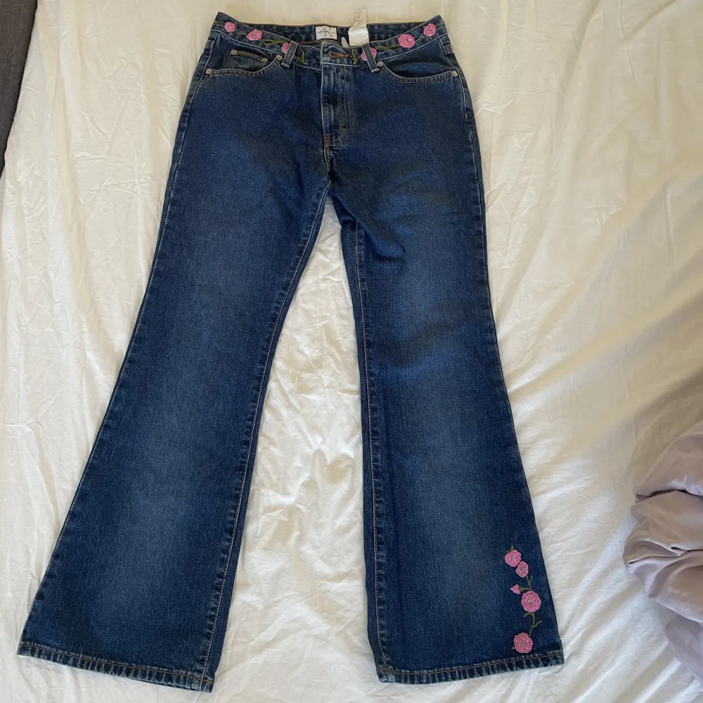 Supersöta jeans med blommor på, i väldigt gott skick🐷 Midjemått:76 cm  Längd:98 cm Innerbensmått:72 cm. Jeans & Byxor.