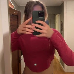 Tropp - En rosa croppad långärmad topp med en vågig skurning nedan, superfin💕