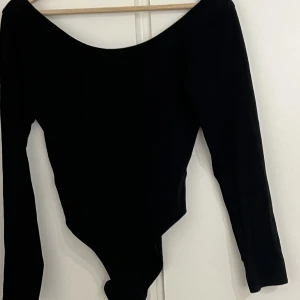 body - Svart body med djup u-ringning på ryggen.