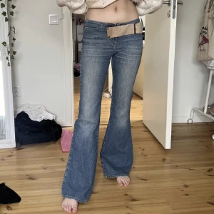 Utsvängda jeans - Säljer dessa fina lågmidjade bootcut jeans med bälte. Jeansen har lite syn på användning men annars i fin sick. Innerbenslängd: 82 cm midjemått: 74cm❤️