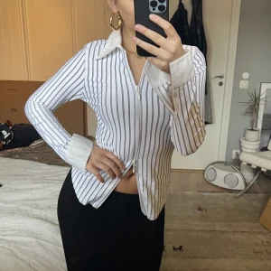 Blus med dragkedja - Jättecool och unik blus med ränder och dragkedja. Jättefin kvalitet och gott skick (köpt second hand och aldrig använd av mig, skulle säga att den är 8/10 i skick!!!) perfekt till fest och till vardags!   Säljer pga används inte 😫😫😫