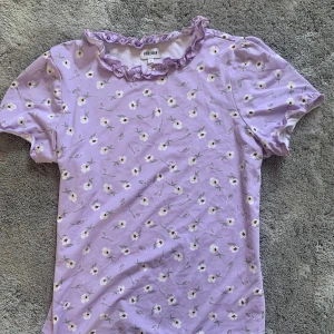 Fin topp  - Fin topp med puffiga armar och en underbar lila färg. Små blommor på toppen. Skönt material. 💜Toppen har inga defekter. 