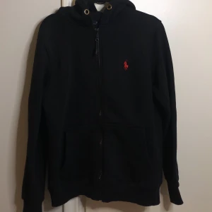 Polo Ralph Lauren zip up hoodie. - En Polo Ralph Lauren zip up hoodie i färgen svart, storlek S, saknar även band till huvan. Annars i bra skick, har använts ett par få gånger. 