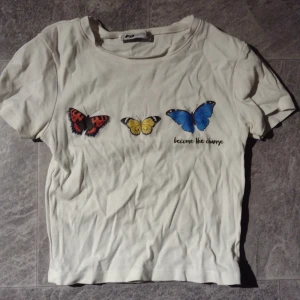 Cropped t-shirt  - Kort t-shirt med tryck och text. Knappt kommit till användning och väljer därför att sälja den. Fint skick strlk XS