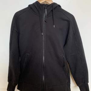 C.P Company hoodie använd flertal gånger men i bra skick. Det finns inga skador eller fläckar på plagget. Passformen är ganska true to size. Nyinköpt för ca 2600kr på NK Göteborg.