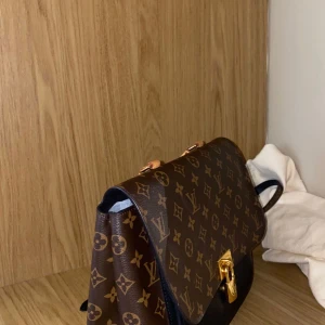 Marignan Louis Vuitton handväska - Detta är en marignan louis Vuitton handväska/bag  Refrensnummer: M44259  Dust bag och invoice kvitto från Louis Vuitton finns  Finns en fläk på framsidan av väskan  Inköpspris: 17600kr