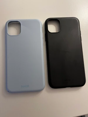 holdit mobilskal - ett ljusblått och ett svart mobilskal från Holdit! 50kr st. det ljusblåa skalet är lite skadat dom syns på sista bilden. därav kan priset sänkas. Passar både Iphone 11 och Iphone Xr! 💞💞 ‼️det svarta är sålt‼️