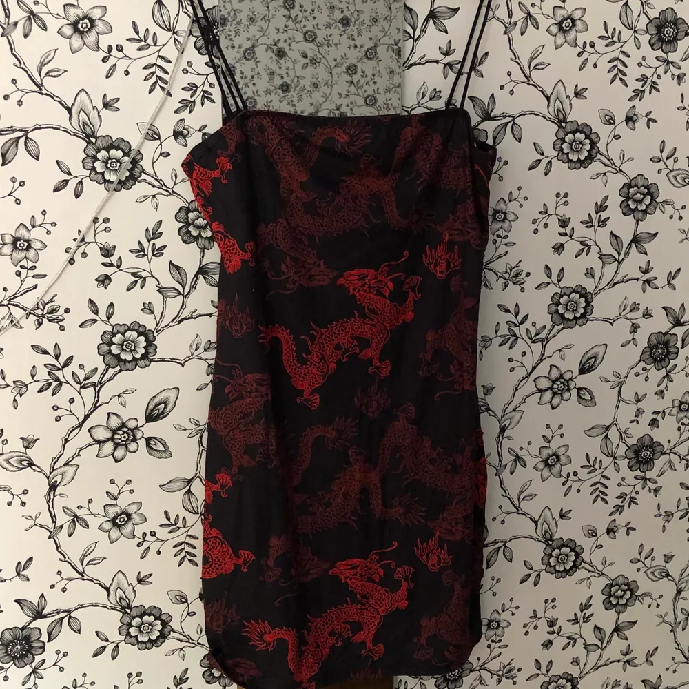 Svart röd klänning med drakmotiv. Oanvänd. Säljer då den är lite för kort på mig (är 181). . Klänningar.