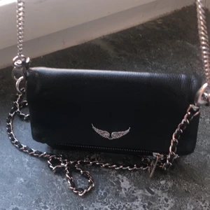 Zadig väska - Säljer min Zadig väska. Lila bandet har gått av men brukar sätta fast de eller bara lägga i det i väskan. Lite rostig på olika stället på kedjan men inget jag tycker men tänker på. Kom privat för fler bilder. Skriv om ni skulle vara intresserade. Köpt förra året för 2000. Pris kan diskuteras vid snabb affär. Först till kvarn om inte fler är intresserade då blir de budgivning. 