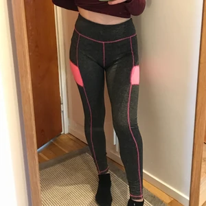Träningsbyxor - Gråa träningsbyxor med rosa detaljer, står inte vilket märke det är. Passar storlek S/M. En liten bit av sömmen långt ner på benet är lite trasig men det påverkar inte byxorna. Skriv för fler bilder. Kan mötas upp annars tillkommer frakt!! Valfri fraktmetod med postnord.