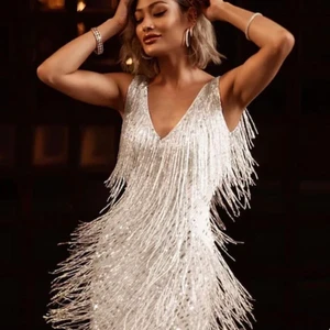 20-tals partyklänning  - En vit kort klänning med långa fransar för härlig rörelse. Silverpaljetter på klänningen. Väldigt liten i storlek, den är M men skulle säga att den mer är XS. Aldrig använd. 