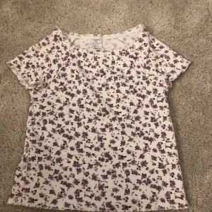 T-shirt I barn storlek  - Vit t-shirt med fina lila blommor på, väldig somrig!
