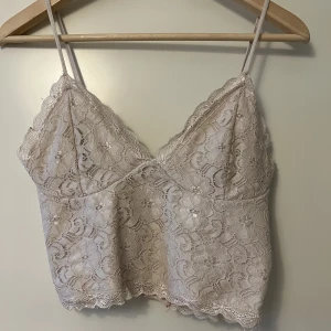 Spets topp  - Säljer denna ljusrosa/beiga spets topp från bikbok. Har endast använt den några enstaka gånger. Superfin att ha för sig själv eller under skjorta, stickad tröja. 